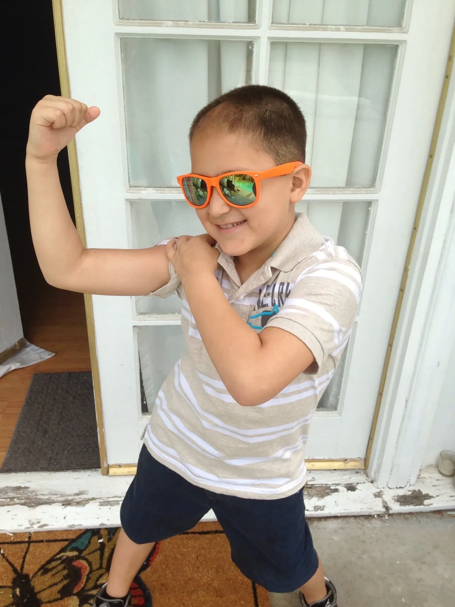 Calvin smiling in orange sunglasses