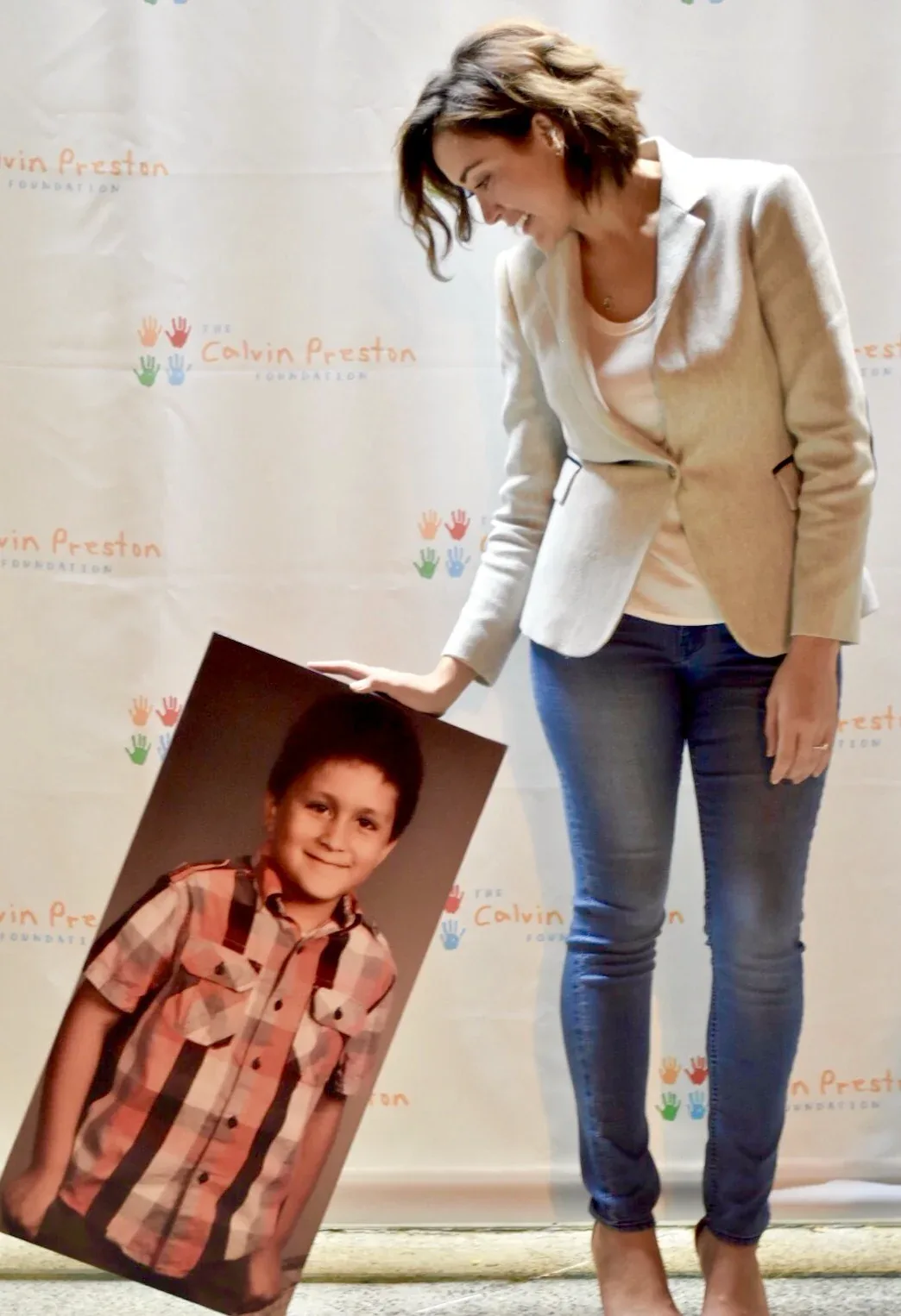 Mary beside a portrait of Calvin at a foundation event